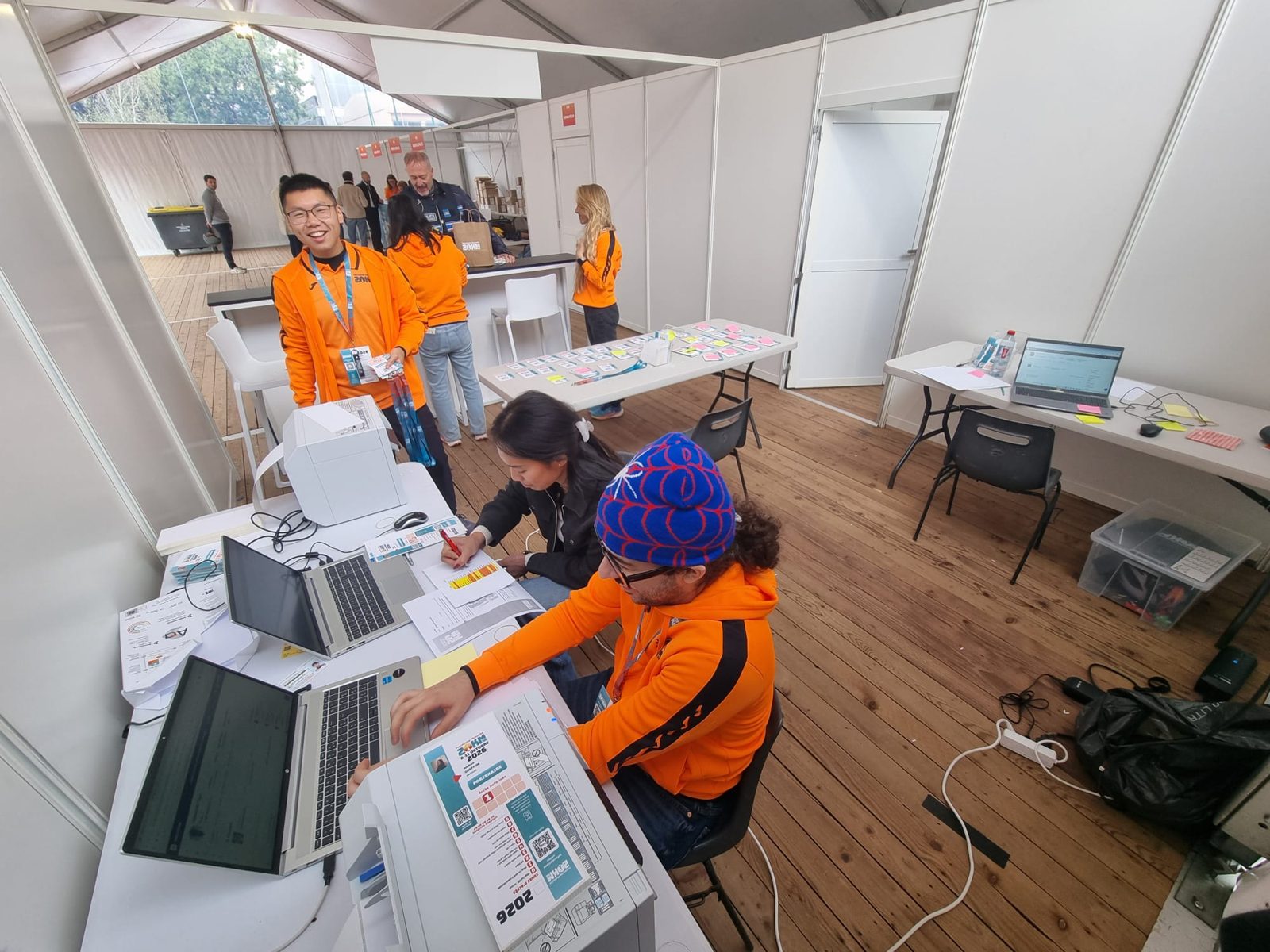 Poste d'impression des accréditations AESPASS aux 20 km de Paris 2026, avec ordinateurs portables et imprimantes à badges